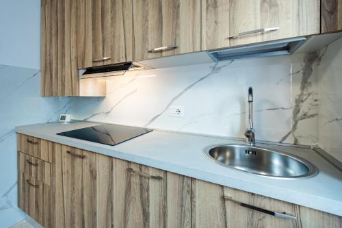 a kitchen with a sink and wooden cabinets at Appartamento Squarà - con Vista Cascata, vicino Verona in Montorio Veronese