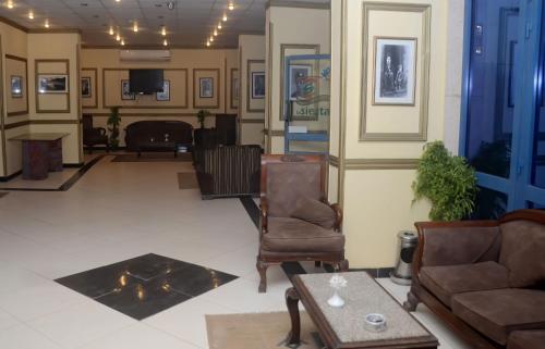 um átrio com um sofá, uma cadeira e uma mesa em New Siesta Hotel & Resort em Alexandria