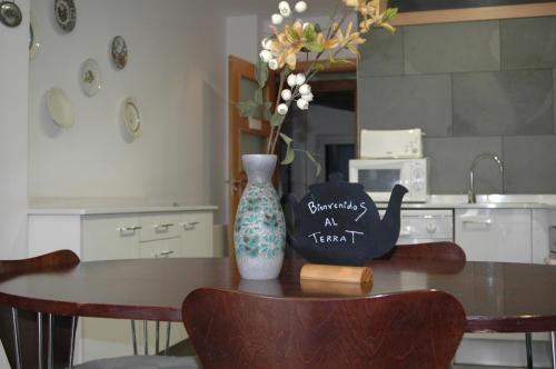 a dining room table with a vase and a vase at El Terrat Sobre el Mercat in La Seu d'Urgell