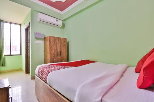 um quarto com uma cama num quarto com paredes verdes em OYO Hotel Happy Journey em Dīgha