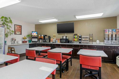 a dining room with tables and chairs and a tv at Econo Lodge Augusta, Downtown in Augusta