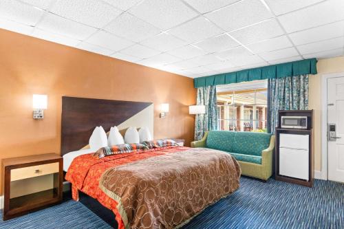 una camera d'albergo con letto e sedia di Rodeway Inn Historic a Williamsburg