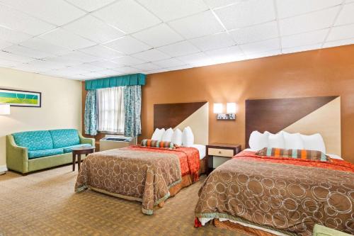 a hotel room with two beds and a couch at Rodeway Inn Williamsburg Edge District in Williamsburg