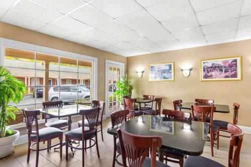 a restaurant with tables and chairs in a room at Rodeway Inn Williamsburg Edge District in Williamsburg