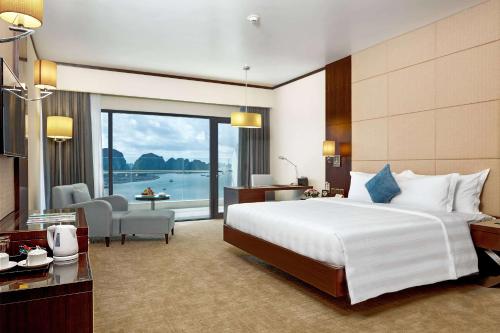 a hotel room with a bed and a view of the water at Wyndham Legend Halong in Ha Long