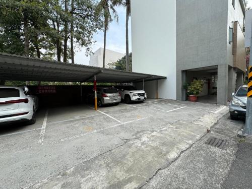 a parking lot with two cars parked in it at 慶東雙包棟招待所 兩棟可選擇包層包棟 可住4-70人 團體聚會首選 in Tainan