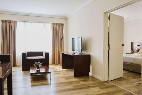 a hotel room with a bedroom with a bed and a television at Dazzler by Wyndham Buenos Aires San Martin in Buenos Aires