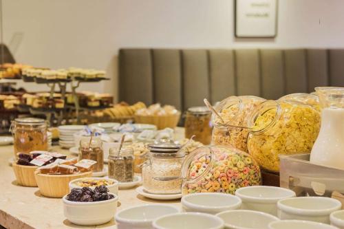 a table filled with dishes and jars of food at Dazzler by Wyndham Buenos Aires San Martin in Buenos Aires