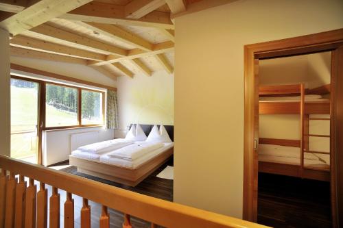 a bedroom with a bed and a balcony at Familienhotel Moos-Alm in Lienz
