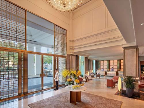 a lobby of a building with a person standing in the distance at Mövenpick Hotel Hanoi Center in Hanoi