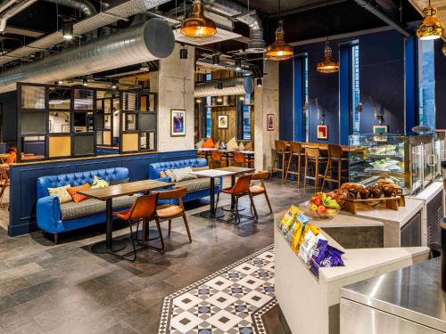un restaurante con paredes azules, mesas y sillas en ibis Budget Sheffield Centre St Marys Gate, en Sheffield