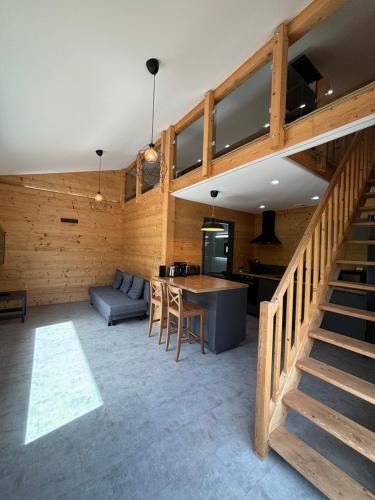 une cuisine et un salon avec une table et un canapé dans l'établissement Les Chalets Perce Neige & Jacuzzi privatif, proximité Gerardmer & La Bresse, à Rochesson