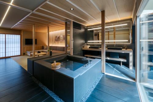 a large bathroom with a tub in the middle at ANJIN Gosho Ebisugawa in Kyoto