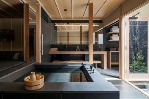 a kitchen with black countertops and wooden ceilings at ANJIN Gosho Ebisugawa in Kyoto