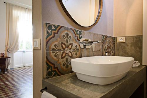 a bathroom with a white sink and a mirror at Tenuta La Moresca in Noto