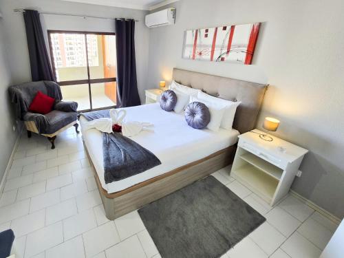 ポルティマンにあるApartment Praia Rocha Cinzaのベッドと椅子と窓のある寝室