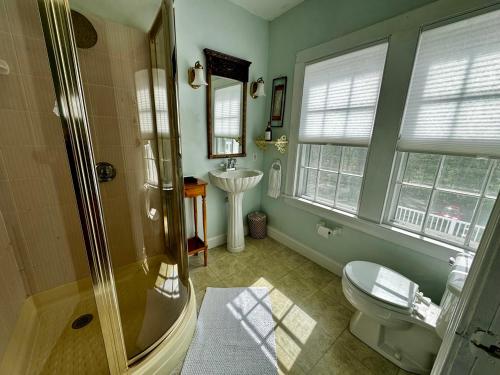 a bathroom with a shower and a toilet and a sink at The Harpswell Inn 