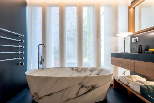 a large marble tub in a bathroom with a window at Atrio in Cáceres