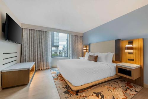 a bedroom with a large bed and a large window at Cambria Hotel Austin Downtown in Austin