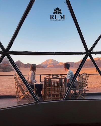 dos personas sentadas en una mesa mirando hacia el agua en Rum desert magic, en Wadi Rum