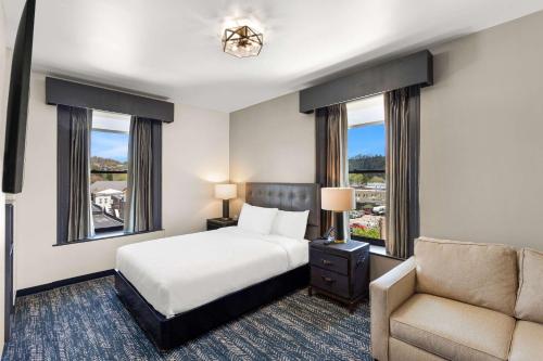 Schlafzimmer mit einem Bett, einem Stuhl und Fenstern in der Unterkunft Tygart Hotel, Ascend Hotel Collection in Elkins