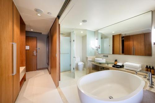 uma casa de banho com uma grande banheira branca num quarto em Centara Grand at Central Plaza Ladprao Bangkok em Bangkok
