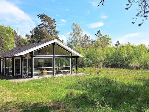 a large glass house in a field with trees at 8 person holiday home in Hadsund in Hadsund
