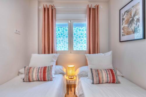 two beds in a room with a window at Apartamento Metropolitano II en Madrid in Madrid