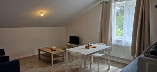 - un salon avec une table blanche et une fenêtre dans l'établissement Au Pied de la BASILIQUE, à Bourg-en-Bresse