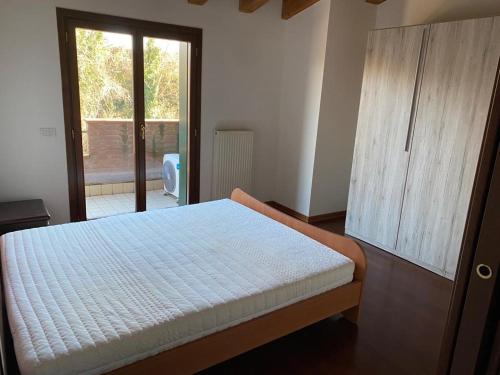Appartamento luminoso في سان جورجيو دي نوجارو: غرفة نوم بسرير وخزانة خشبية