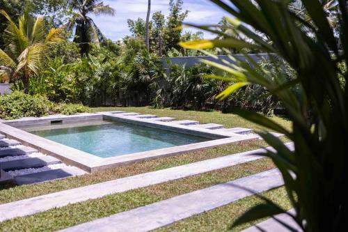 una piscina nel mezzo di un giardino di Villa Allure & Villa Ahurewa ad Ahangama