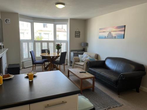 a living room with a couch and a table at St Margarets Modern Georgian 2 bedroom apartment in Ryde