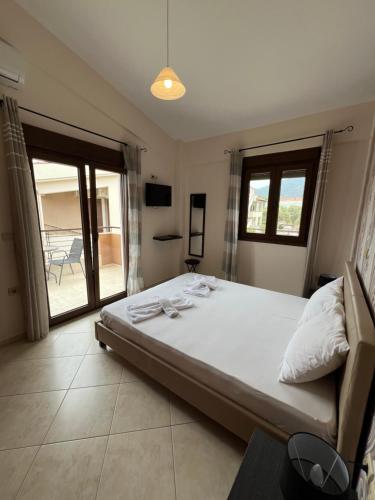 a bedroom with a large bed and a balcony at Penelope's Maisonette in Skala Potamias