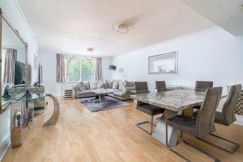 sala de estar con mesa y sofá en Luxury St Johns Wood 2-bed with 24hr Concierge, en Londres