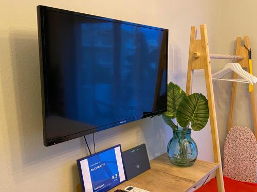 a flat screen tv hanging on a wall with a laptop at B6 COQUETTE in Nea Chili
