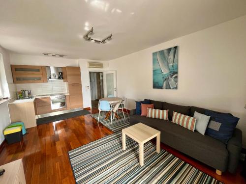 ein Wohnzimmer mit einem Sofa und einem Tisch in der Unterkunft Apartment Picturesque Retreat in Dramalj