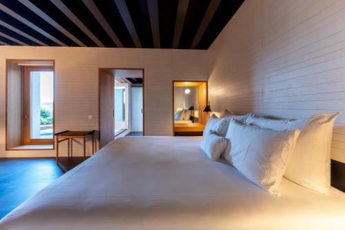 a bedroom with a large white bed and a bathroom at Atrio in Cáceres