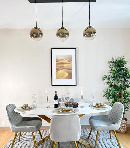 une salle à manger avec une table et des chaises blanches dans l'établissement Spacious Flat near Porte de Versailles, à Paris