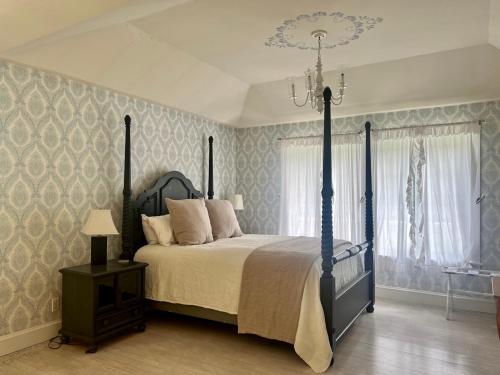 a bedroom with a bed and a chandelier at The Harpswell Inn in Harpswell Center