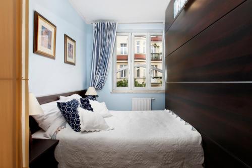 a bedroom with a large bed and a window at Lapwing Apartments Monte Cassino in Sopot