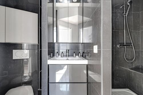 une salle de bain avec une douche, un lavabo et des toilettes dans l'établissement Residence central marais, à Paris