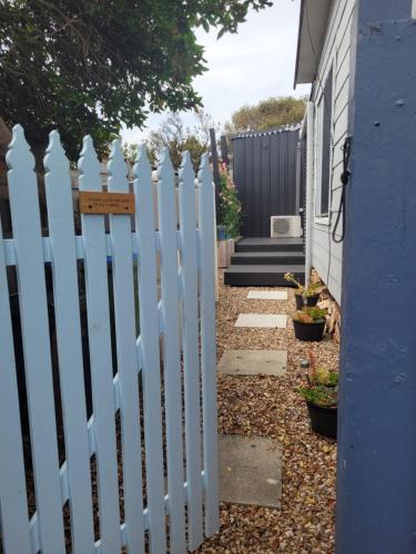 a white picket fence in front of a house at Shore Thing Beach Escape in Saint Andrews Beach