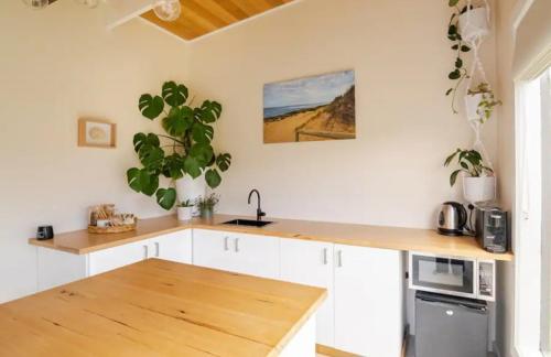 a kitchen with white cabinets and a wooden counter top at Shore Thing Beach Escape in Saint Andrews Beach