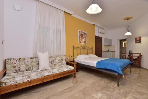 a bedroom with a bed and a couch at Paleochora Elizabeth Apartments in Palaiochora
