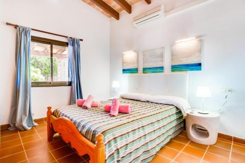 - une chambre dotée d'un lit avec des oreillers roses dans l'établissement Finca ROTES Pollensa, à Port de Pollença