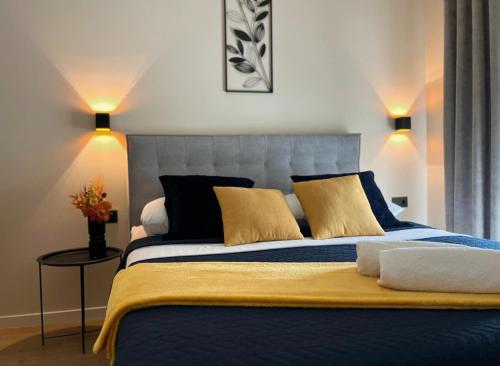 a bedroom with a large blue bed with yellow pillows at Apartment Mate in Pridraga