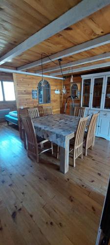 une salle à manger avec une grande table et des chaises en bois dans l'établissement Logement cosy au pied des pistes, à Saint-Pierre-dels-Forcats