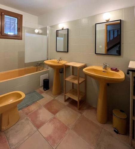 une salle de bain avec deux lavabos, un miroir et une baignoire dans l'établissement Maison de caractère avec piscine 1h de Toulouse, à Saint-Cirq