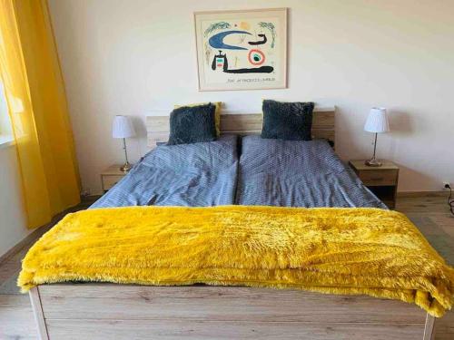- une chambre avec un grand lit et une couverture jaune dans l'établissement 45m2 Buda hillside with panorama & free parking!, à Budapest