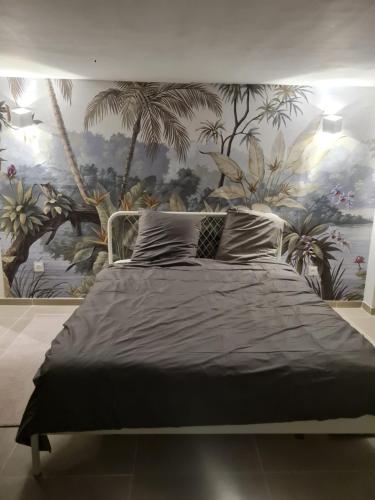 sypialnia z dużym łóżkiem i malowidłem ściennym w obiekcie Maison village vignoble avec balnéo w mieście Mailly-Champagne